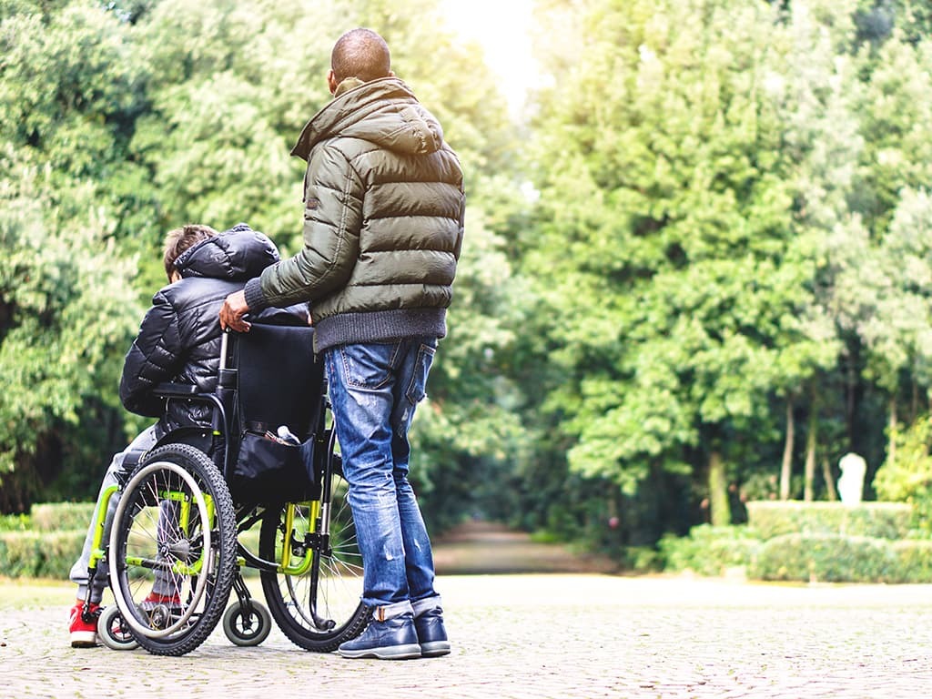 Young man in wheelchair with juvenile ALS