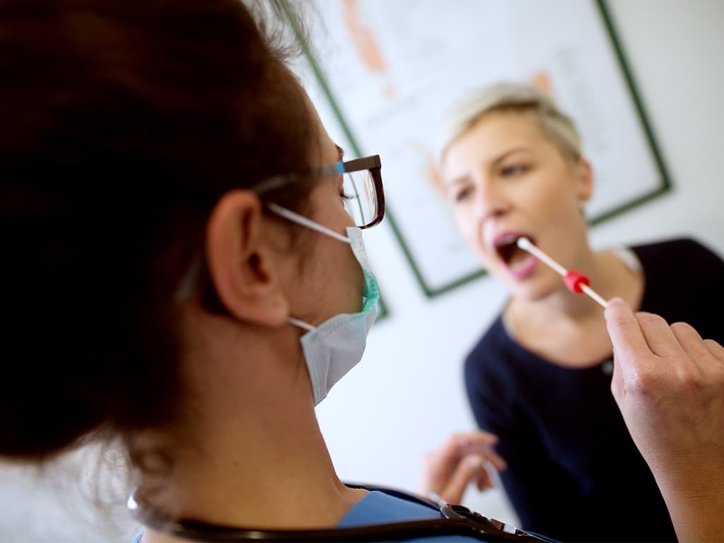 Doctor taking a saliva sample for an ALS genetic test