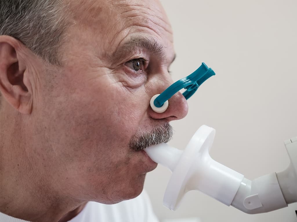 ALS patient doing a spirometer lung function test